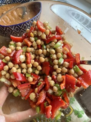glass bowl with chickpeas, red bell pepper, spring onions, mixed with oil and spices
